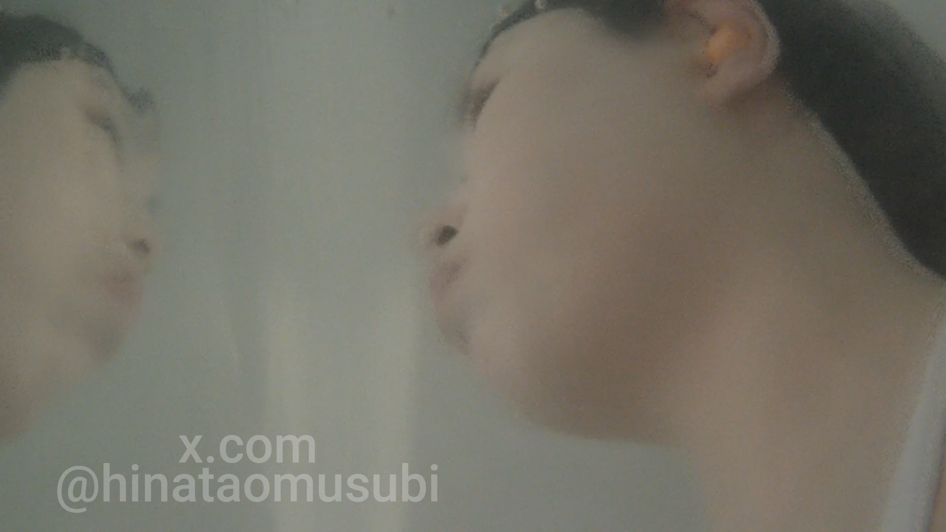 水中で息止めをする女子の幻想的な横顔。水面に顔が反射している。
