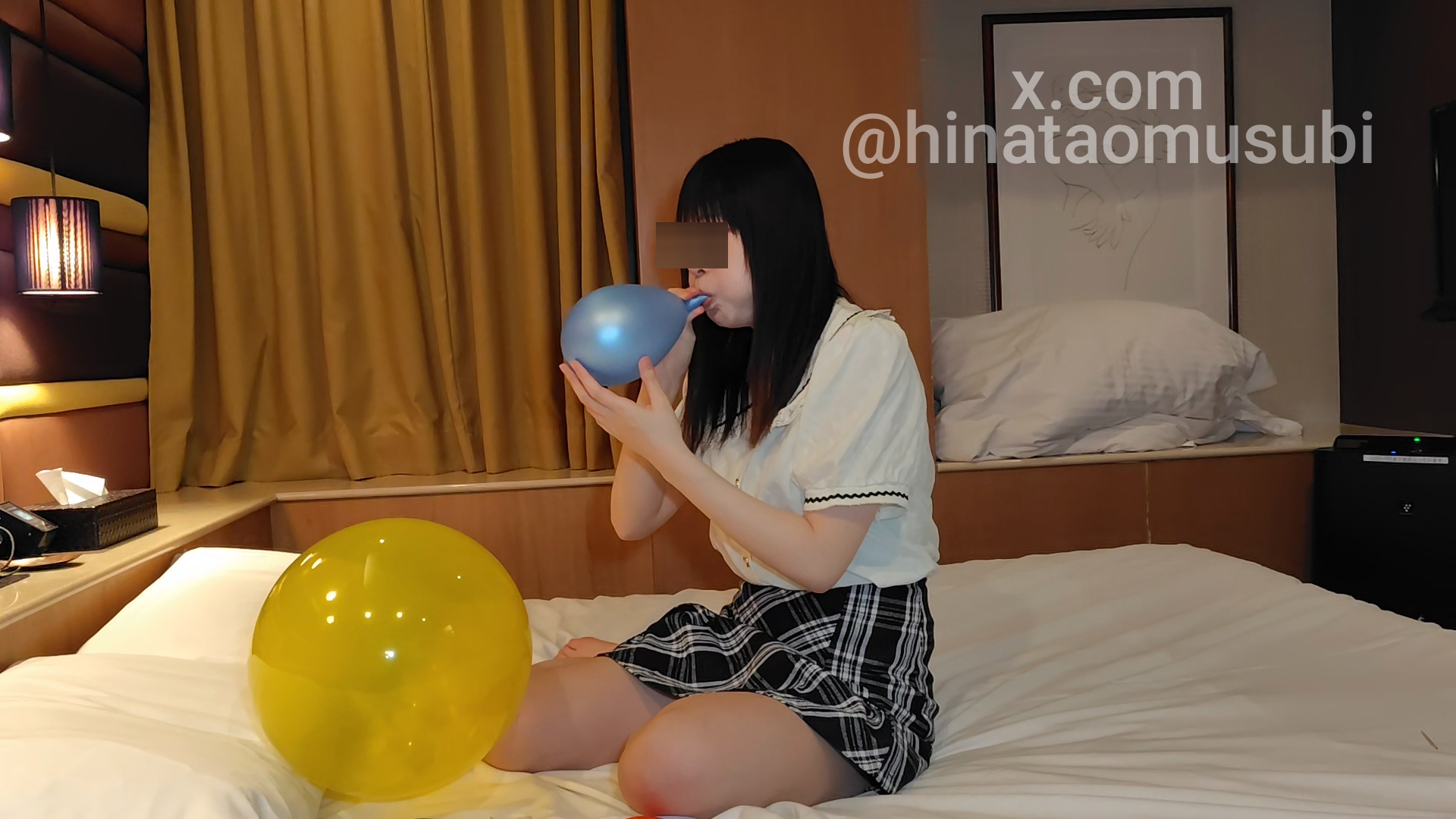 銀色の風船を膨らませる女の真剣な姿