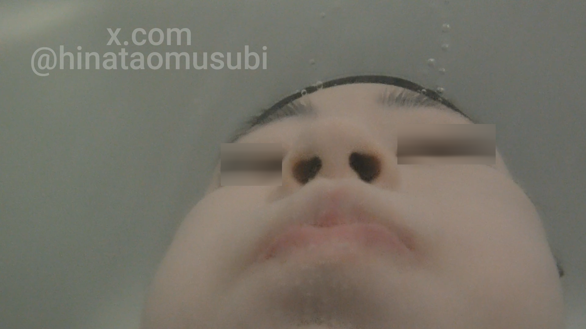 水中で仰向けに息を止める女の子の顔。下からのアングルで鼻と口元を映す。